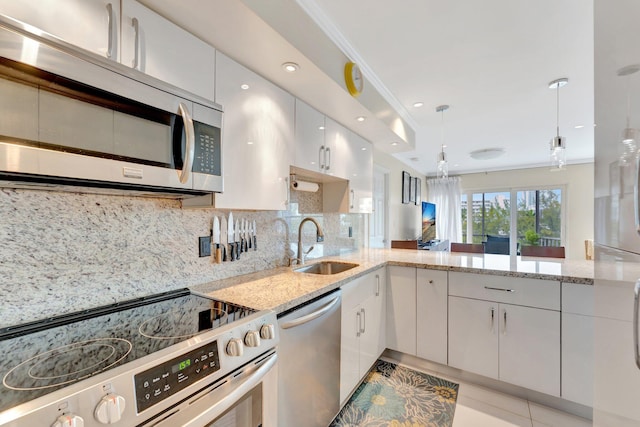 kitchen featuring a sink, decorative backsplash, white cabinetry, and stainless steel appliances