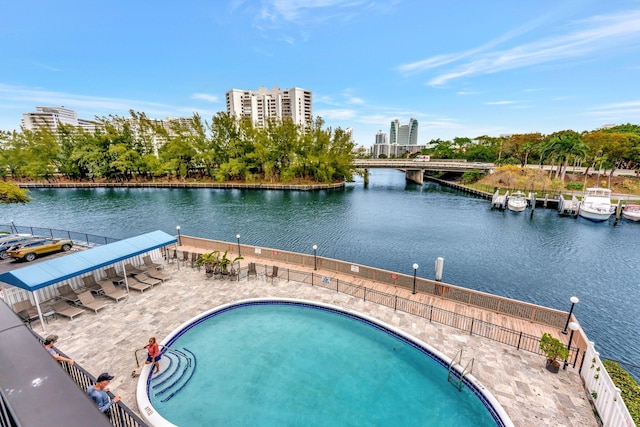 community pool with a city view, a patio, and a water view