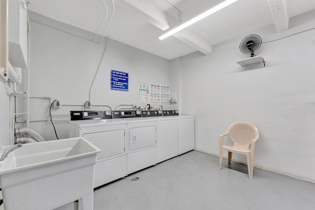 shared laundry area featuring separate washer and dryer and a sink