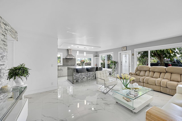 living area with baseboards and marble finish floor