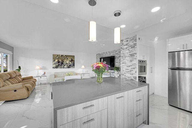 kitchen featuring open floor plan, marble finish floor, modern cabinets, and freestanding refrigerator