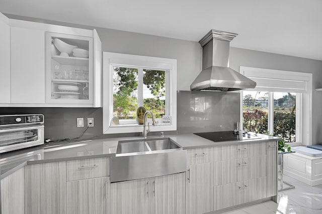 kitchen featuring a sink, extractor fan, light countertops, black electric cooktop, and tasteful backsplash