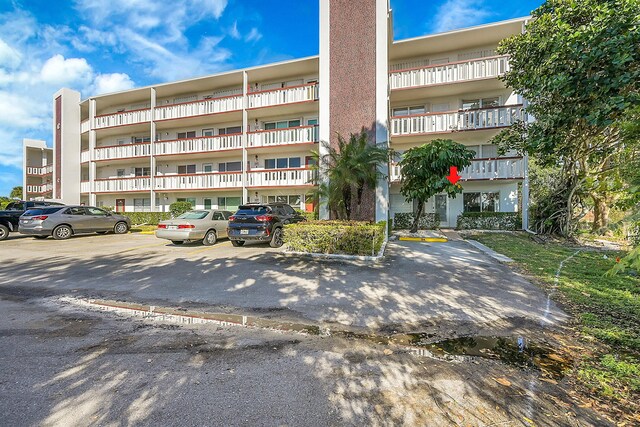 114 Greenbrier Unit C, West Palm Beach, FL 33417 - view of building exterior with uncovered parking