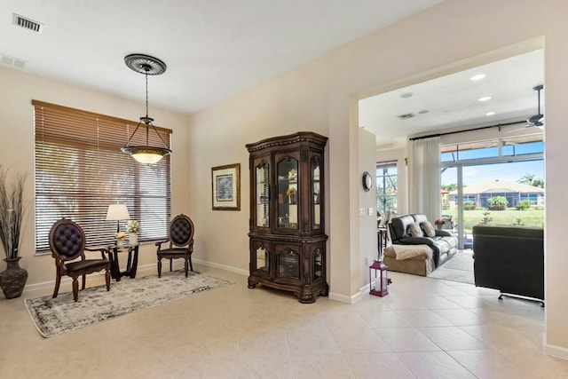 living area featuring a wealth of natural light, visible vents, baseboards, and light tile patterned floors