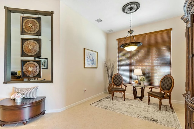 living area featuring tile patterned flooring, visible vents, and baseboards