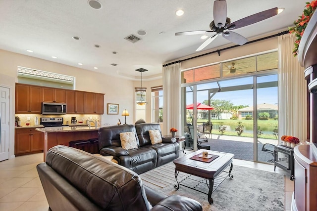 living area with light tile patterned flooring, recessed lighting, visible vents, and ceiling fan