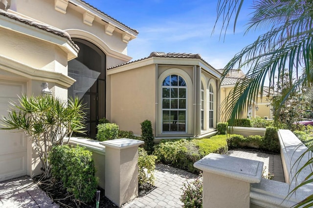 view of side of property featuring stucco siding and a tile roof