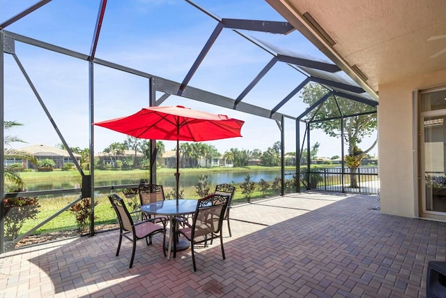 view of patio / terrace with a water view, a lanai, and outdoor dining space