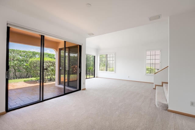 carpeted empty room with stairway, baseboards, and visible vents