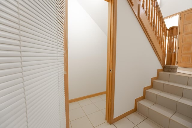 stairway featuring tile patterned floors and baseboards