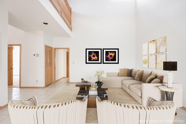 living area with baseboards, a high ceiling, and light tile patterned flooring