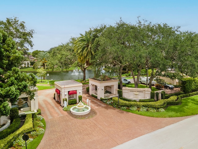 surrounding community featuring decorative driveway and a water view