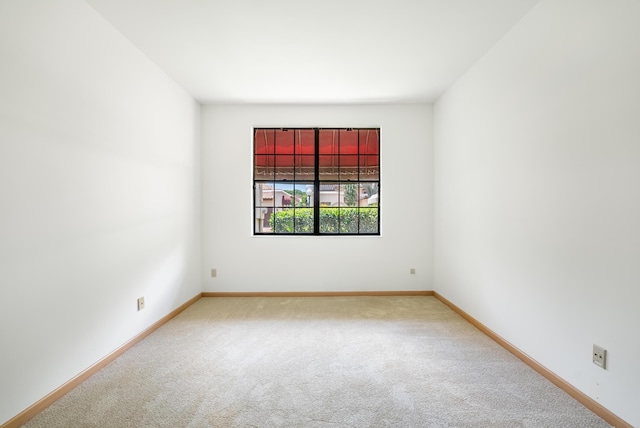 spare room with baseboards and carpet