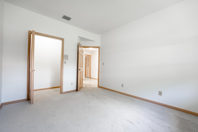 unfurnished bedroom with baseboards, visible vents, and light carpet