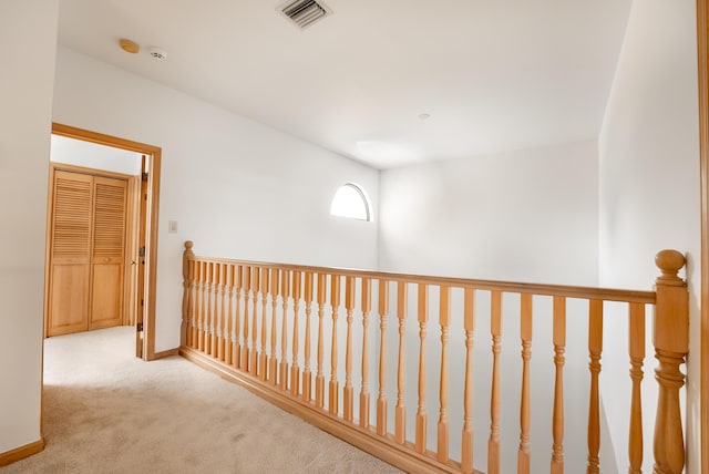 hall featuring visible vents, baseboards, and carpet