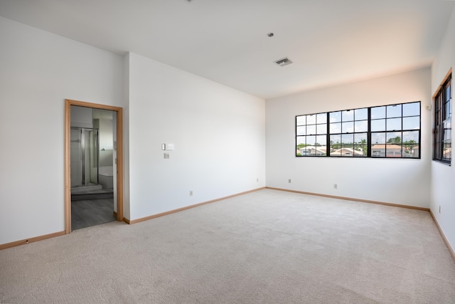 carpeted empty room with visible vents and baseboards