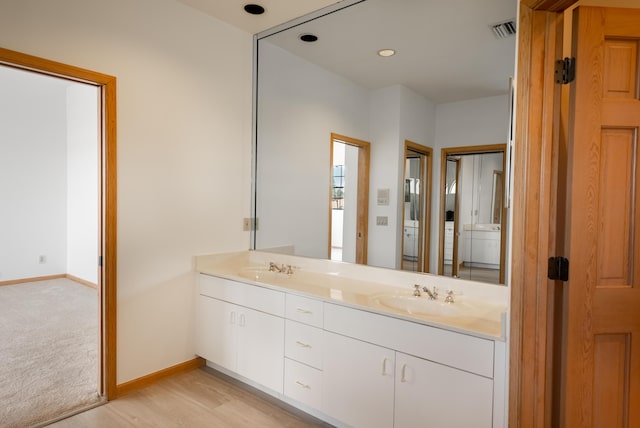 full bathroom with a sink, visible vents, baseboards, and double vanity