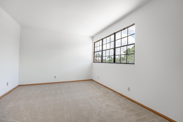 empty room with baseboards and light carpet