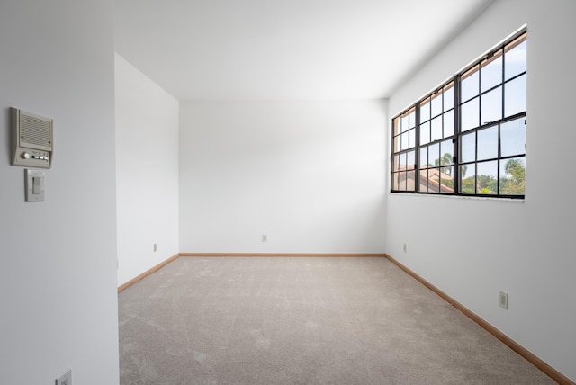 spare room with baseboards and carpet floors