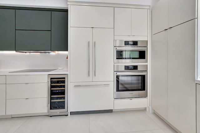 kitchen with paneled fridge, modern cabinets, beverage cooler, double oven, and light countertops