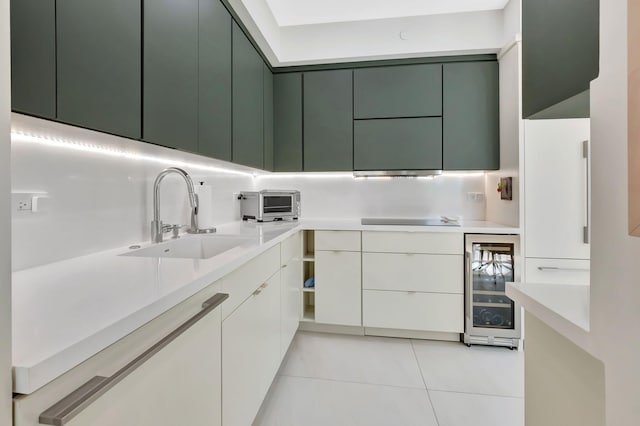 kitchen featuring black electric stovetop, beverage cooler, light countertops, modern cabinets, and a sink