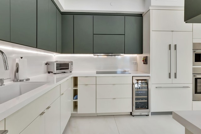 kitchen featuring a toaster, a sink, light countertops, wine cooler, and black electric cooktop