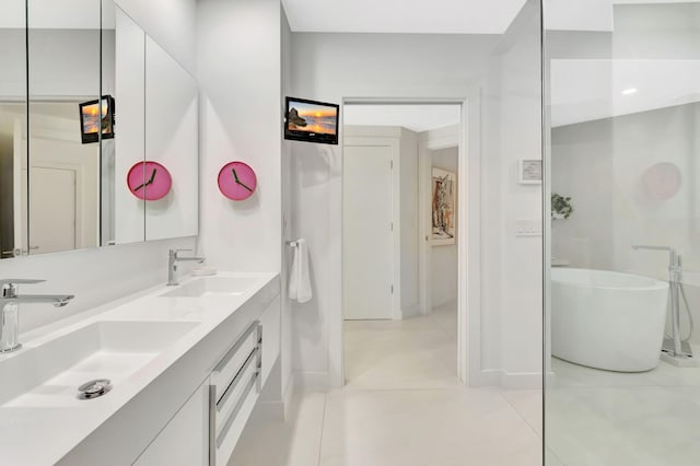 full bath featuring double vanity, a freestanding tub, baseboards, and a sink