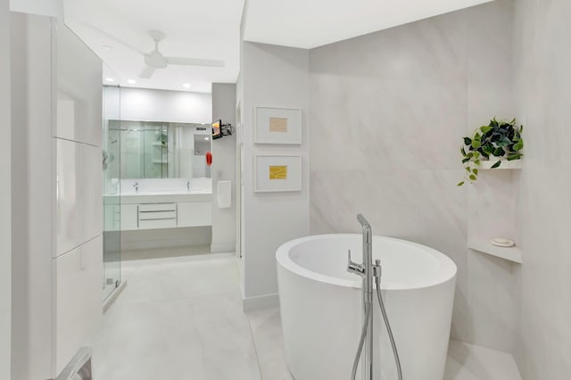 bathroom featuring tile patterned floors, tile walls, a shower stall, a freestanding bath, and vanity