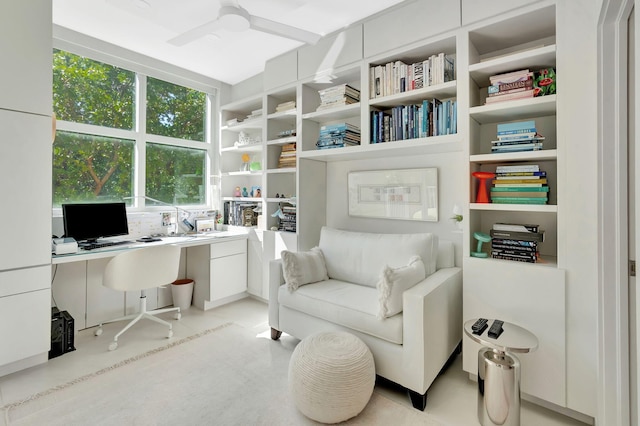 home office featuring built in shelves, a ceiling fan, and built in study area