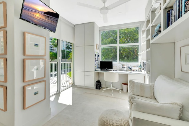 office space featuring finished concrete flooring, a ceiling fan, and built in study area