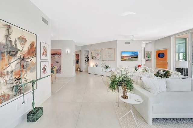 living room featuring tile patterned floors, visible vents, and ceiling fan