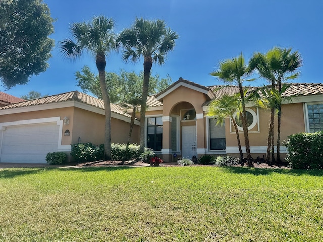 view of front of house featuring a front yard, an attached garage, a tile roof, and stucco siding