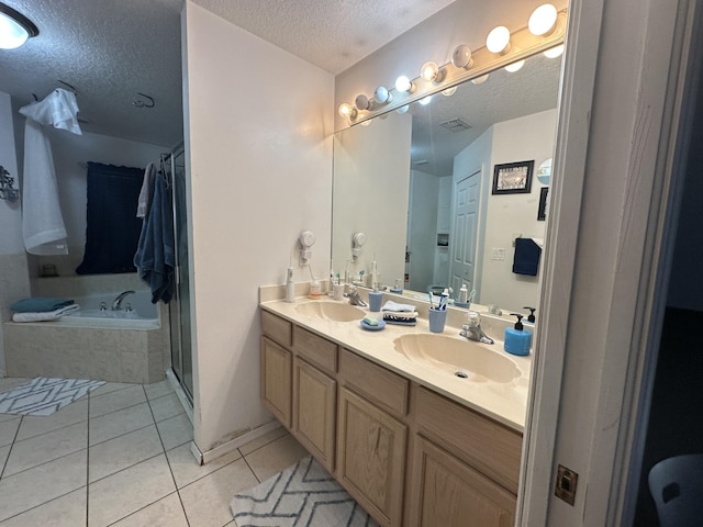 full bath with double vanity, a sink, tile patterned flooring, a textured ceiling, and a bath