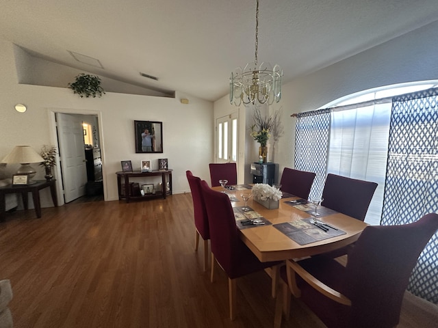 dining area featuring a chandelier, visible vents, wood finished floors, and vaulted ceiling