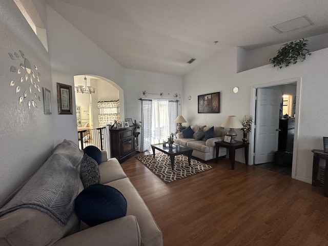 living room featuring visible vents, lofted ceiling, a notable chandelier, and wood finished floors