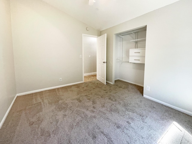 unfurnished bedroom featuring baseboards, lofted ceiling, carpet, and a ceiling fan