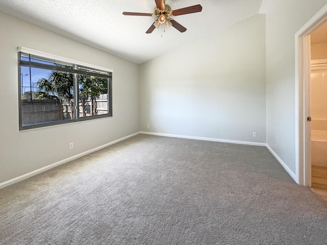 unfurnished room featuring a ceiling fan, a textured ceiling, carpet flooring, baseboards, and vaulted ceiling