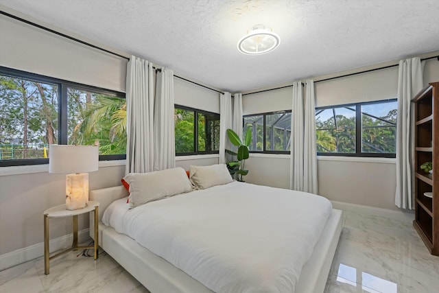 bedroom featuring baseboards, a textured ceiling, and marble finish floor