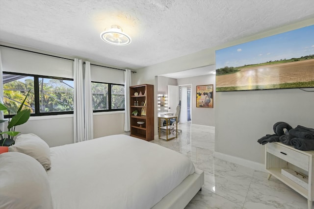 bedroom featuring marble finish floor, a textured ceiling, and baseboards