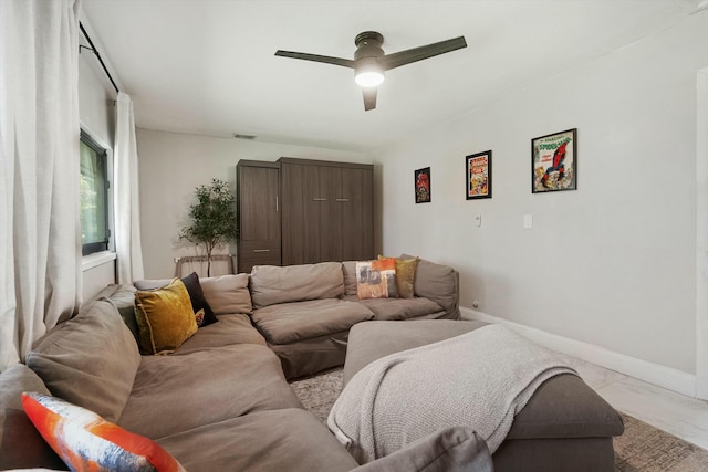 living area featuring visible vents, baseboards, marble finish floor, and a ceiling fan