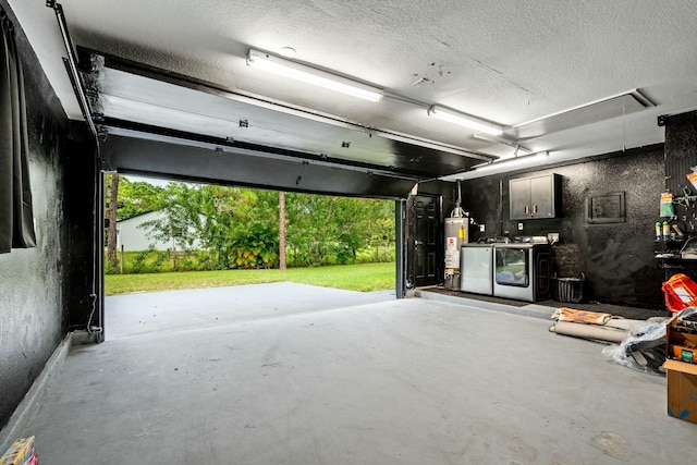 garage featuring washing machine and clothes dryer and gas water heater