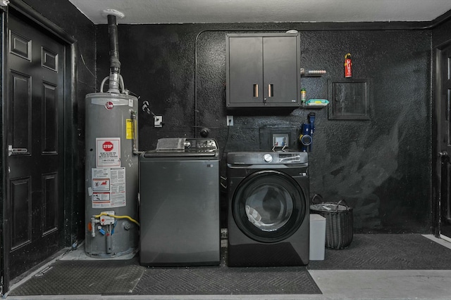 clothes washing area with cabinet space, water heater, and washer and clothes dryer