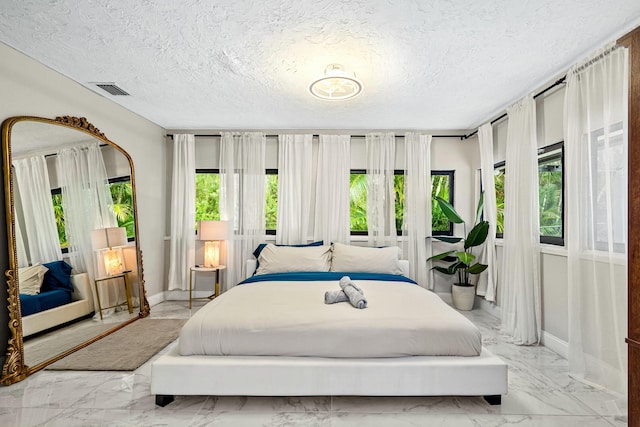 bedroom featuring visible vents, baseboards, a textured ceiling, and marble finish floor