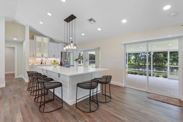 17393 84th Ct N, Loxahatchee, FL 33470 - kitchen featuring stainless steel fridge, white cabinetry, a kitchen bar, baseboards, and recessed lighting