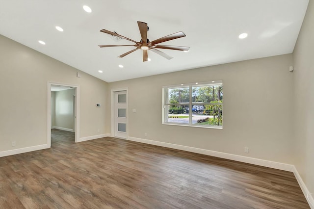 spare room featuring lofted ceiling, wood finished floors, and baseboards