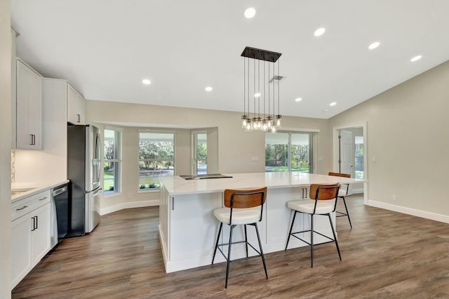 kitchen with a large island, recessed lighting, stainless steel appliances, white cabinets, and lofted ceiling