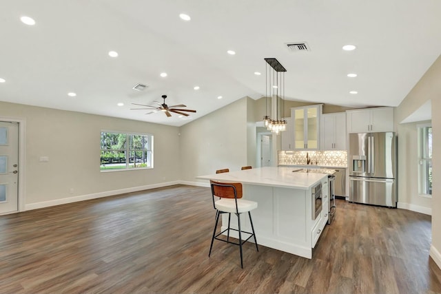 kitchen with visible vents, appliances with stainless steel finishes, white cabinetry, and an island with sink