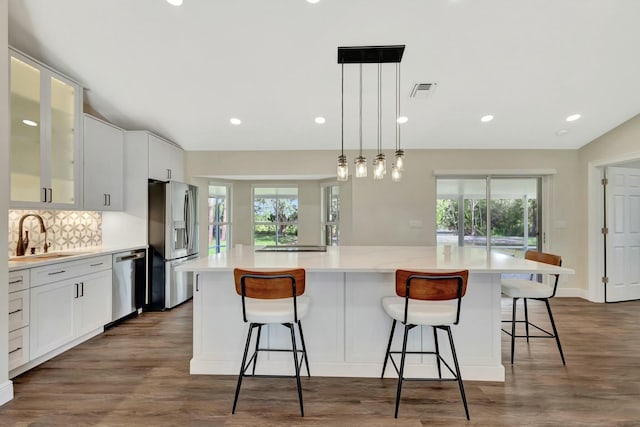 kitchen with a large island, a wealth of natural light, appliances with stainless steel finishes, and a sink