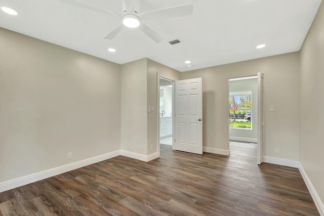 spare room featuring recessed lighting, visible vents, baseboards, and dark wood-style floors