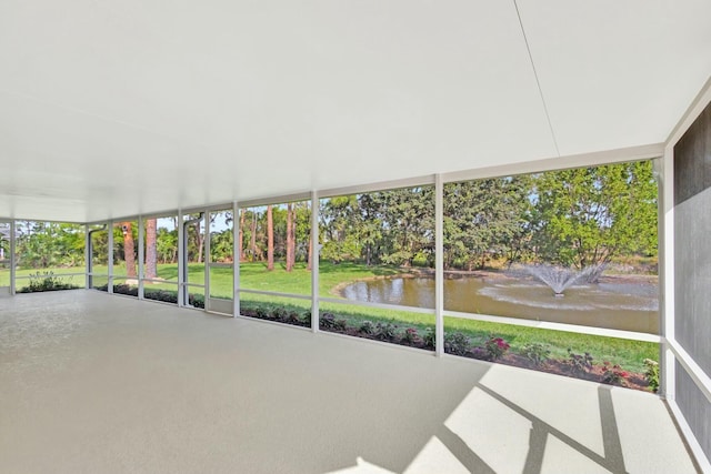 unfurnished sunroom featuring a water view